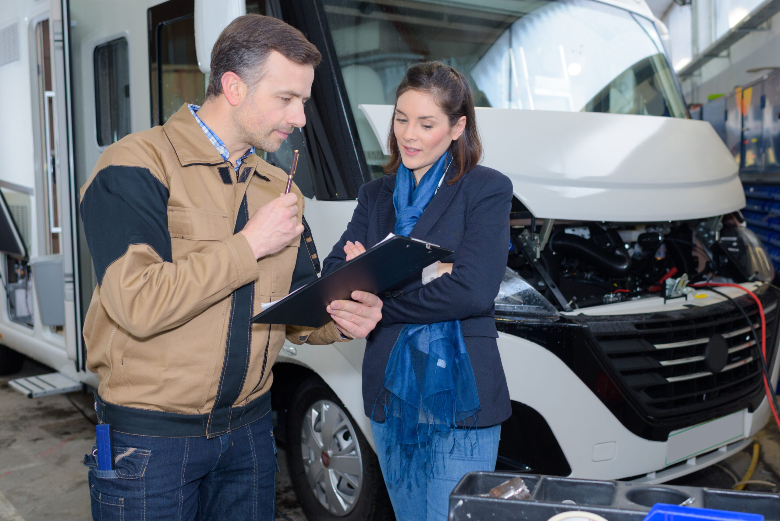 Mechanic discussing motorhome repairs with woman